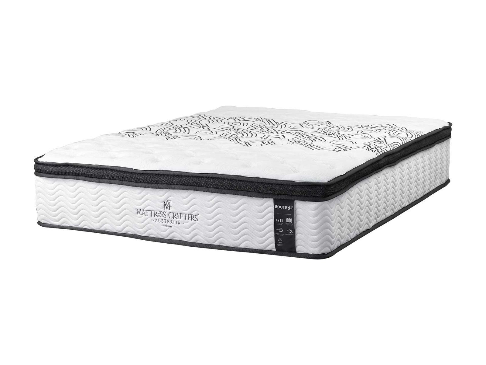 A couple sitting on a Boutique mattress in a bright bedroom